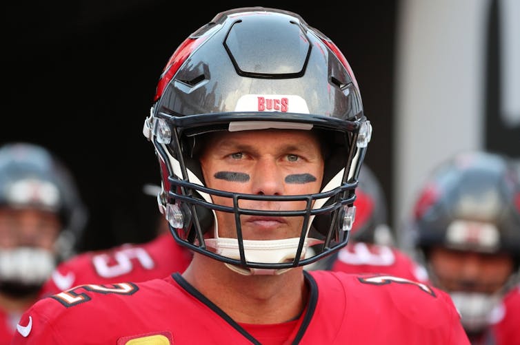 Tom Brady wearing a football helmet.