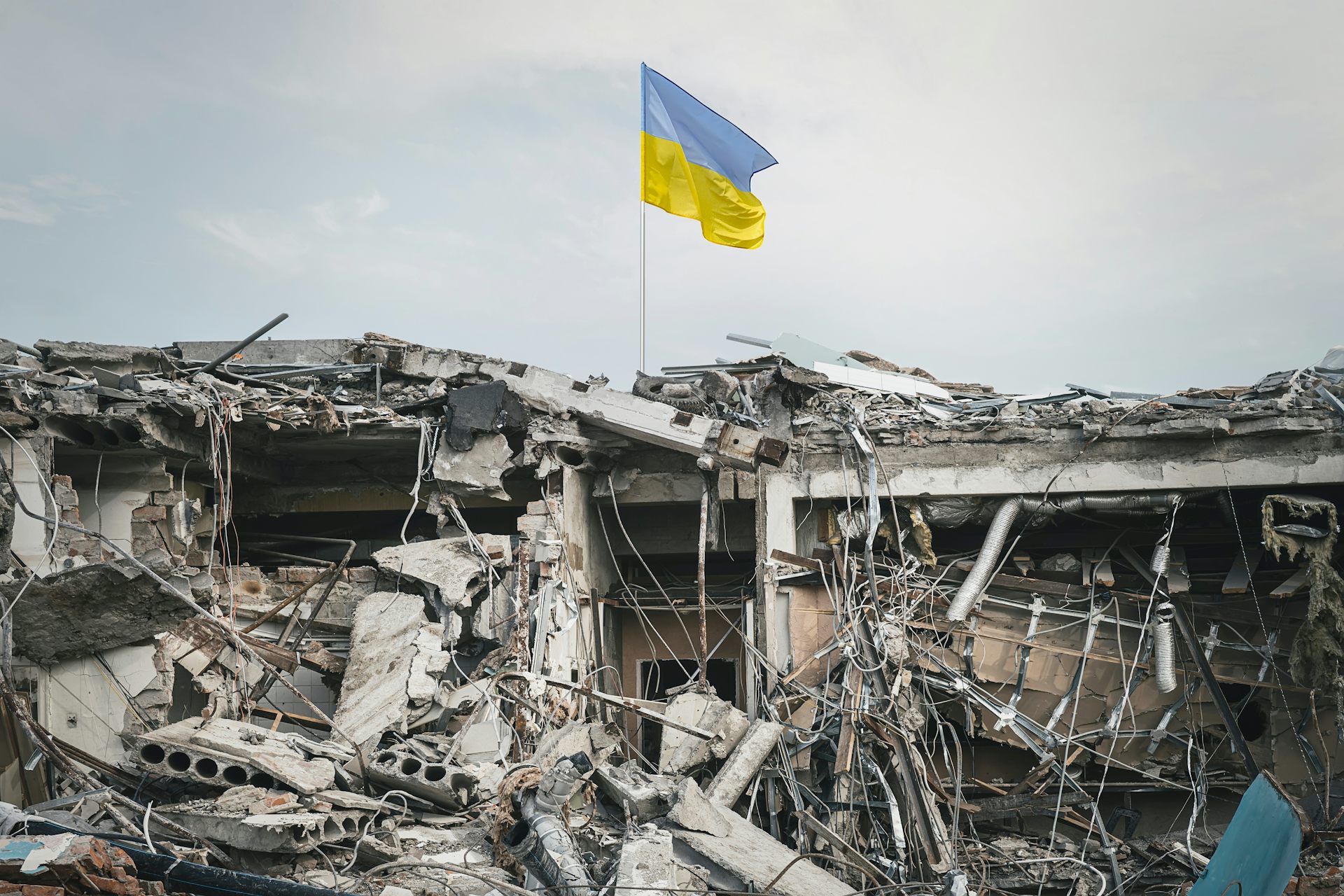 urban rubble with a ukrainian flag flying above it