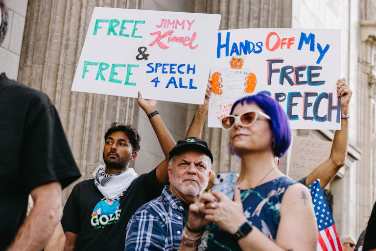 Protesters with signs advocating free speech.