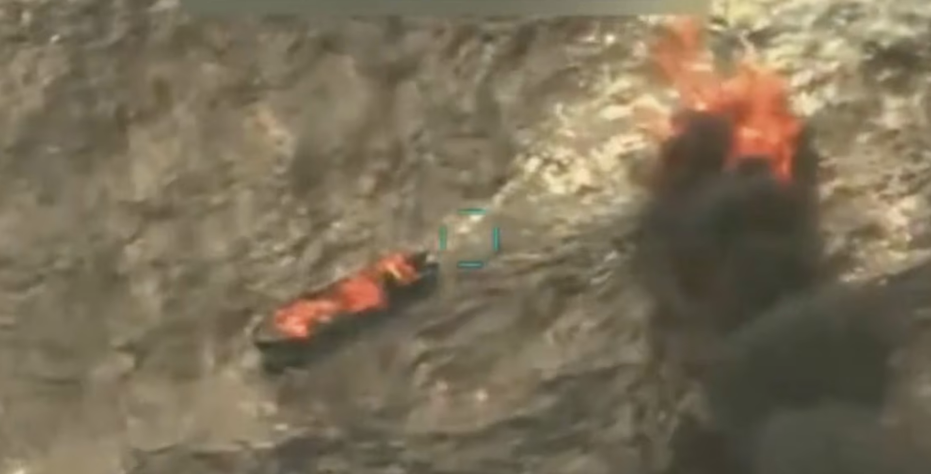 An aerial image shows two vessels at sea on fire.