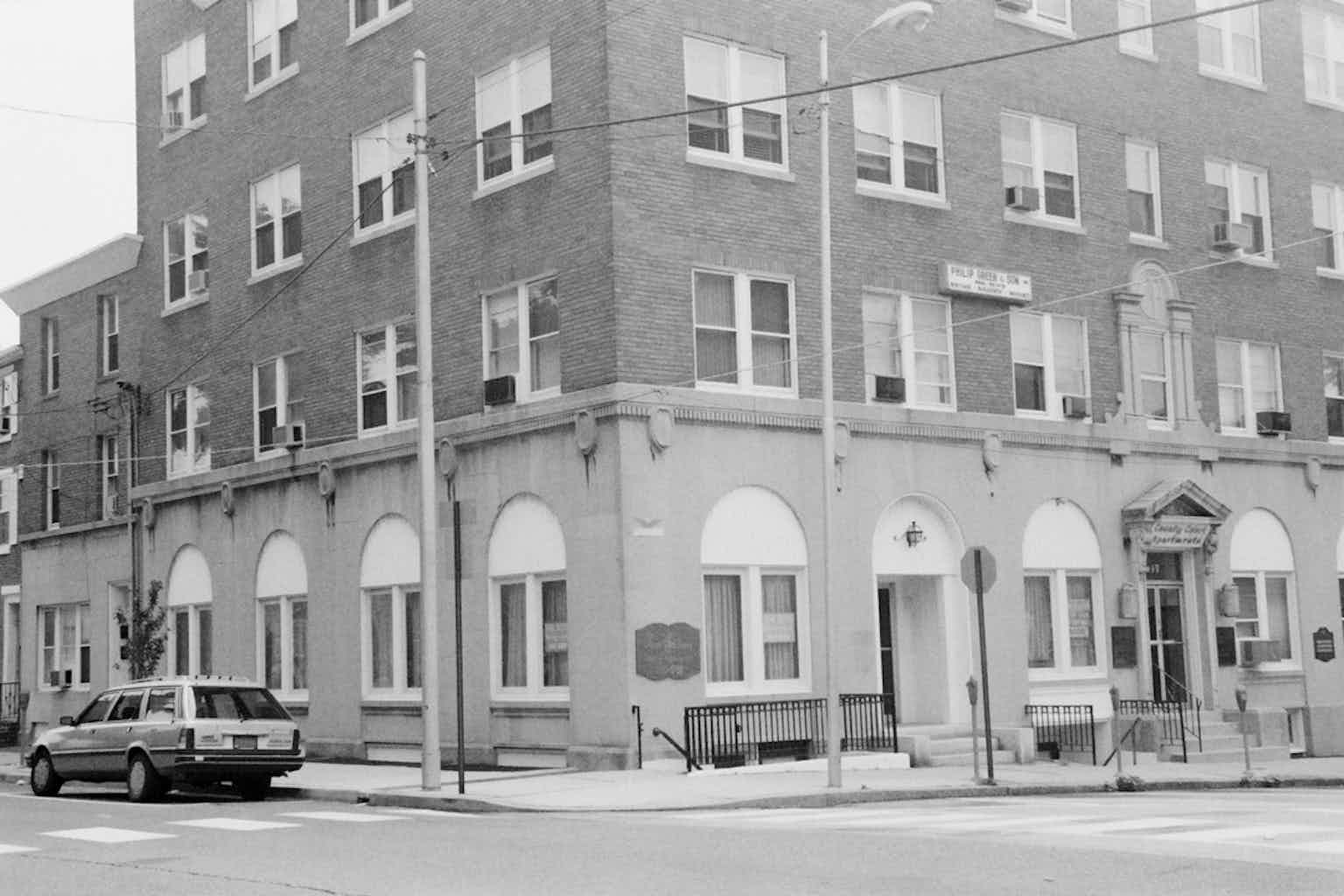 A plain, multistory office or apartment building on a corner.