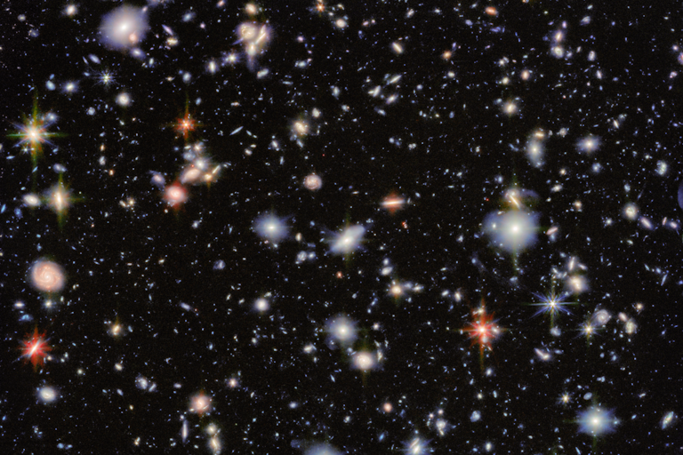 Image of an area of deep space with thousands of galaxies in various shapes and sizes on a black background.