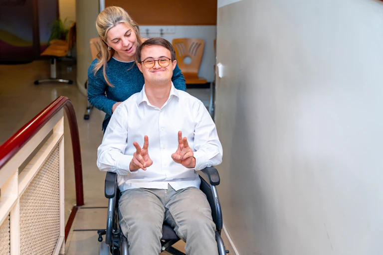 Infirmière transportant une personne handicapée moteur
