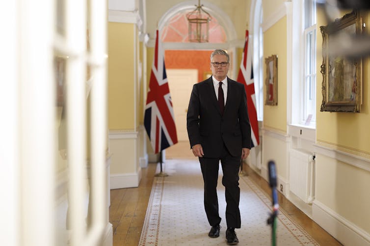 Keir Starmer walking towards a microphone.