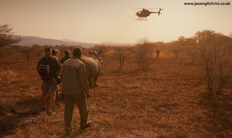 Helicopter, rhino, people