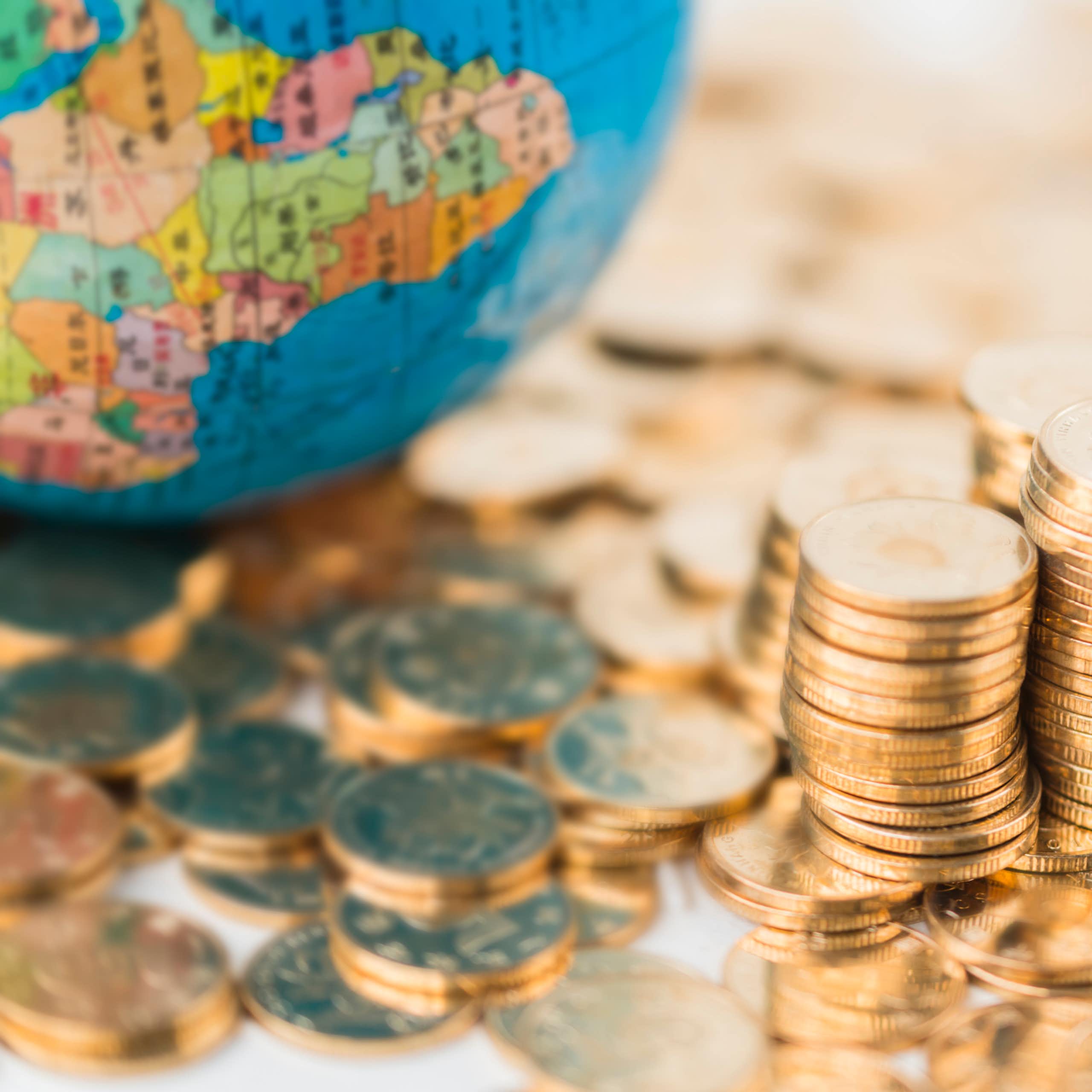 Coins scattered and piled next to a globe with map of Africa on it