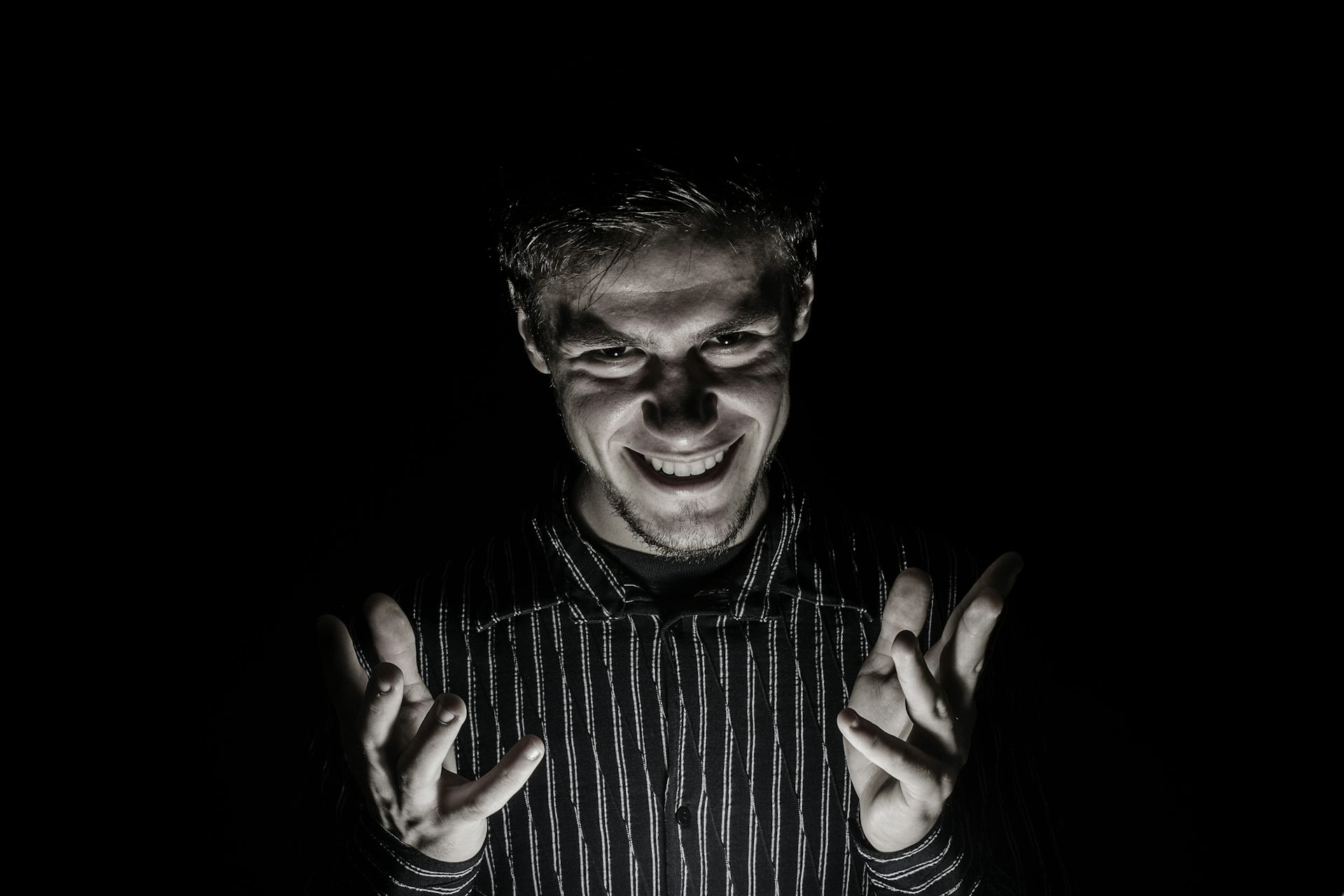 Man portrait with evil look isolated on black background.