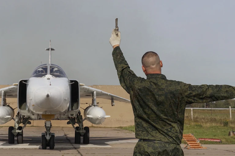 Russian ground crew member directs the pilot of a MIG aircraft preparing to take off, September 2025.