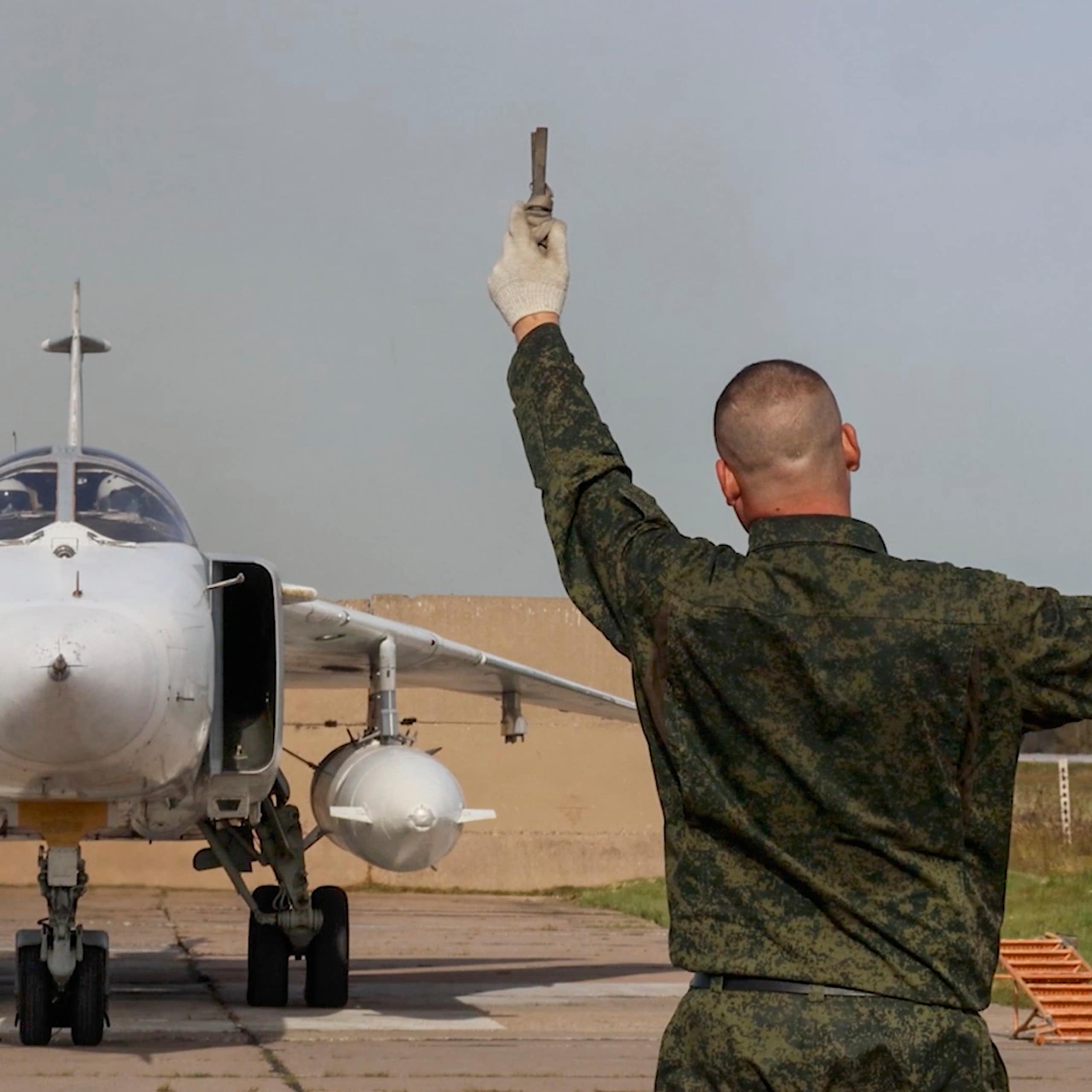 Russian ground crew member directs the pilot of a MIG aircraft preparing to take off, September 2025.