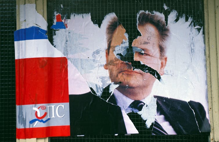 Serbia’s Aleksandar Vučić clings to energy – however protests spotlight the risk of cussed management 1 A torn poster has the image of a man on it.