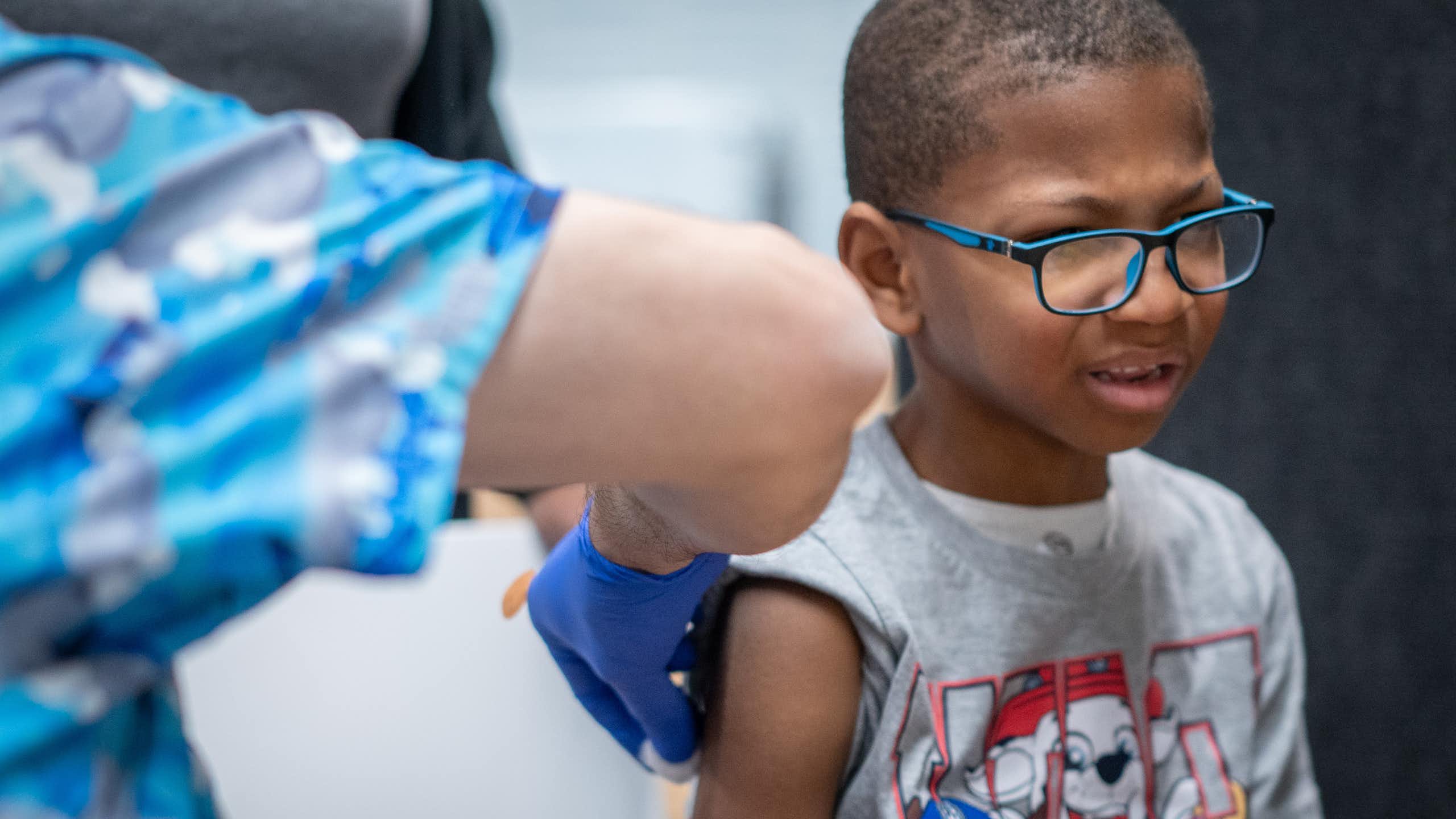 A young boy with a pained look on his face gets a vaccination.
