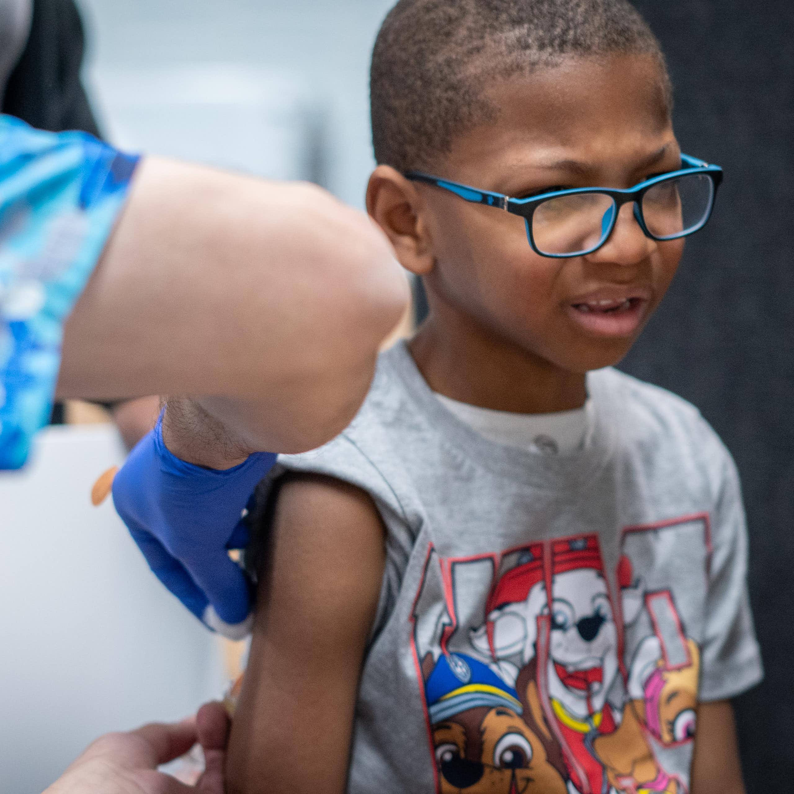 A young boy with a pained look on his face gets a vaccination.