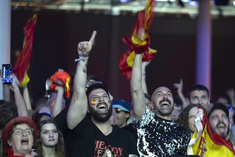 People cheer with Spanish flags.