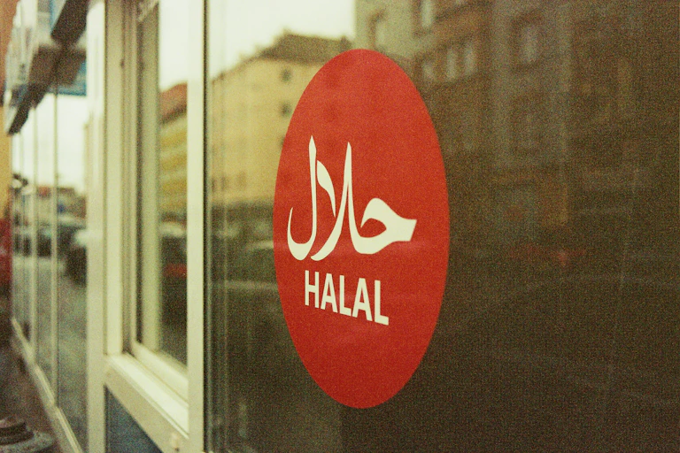 A red circle on a window that says halal in english and arabic