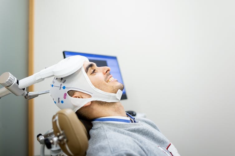 A man receiving transcranial magnetic stimulation therapy.