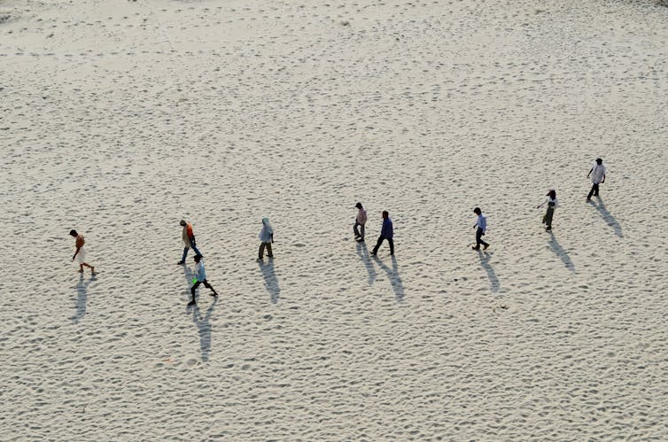 People walk on sandy riverbed