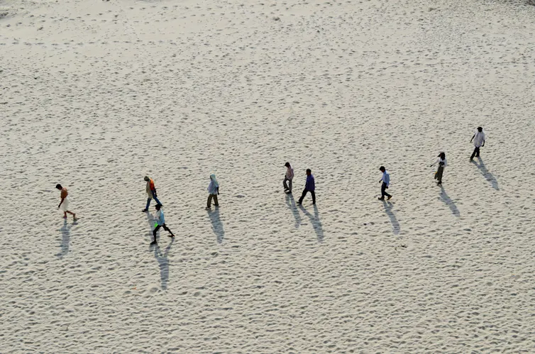 People walk on sandy riverbed