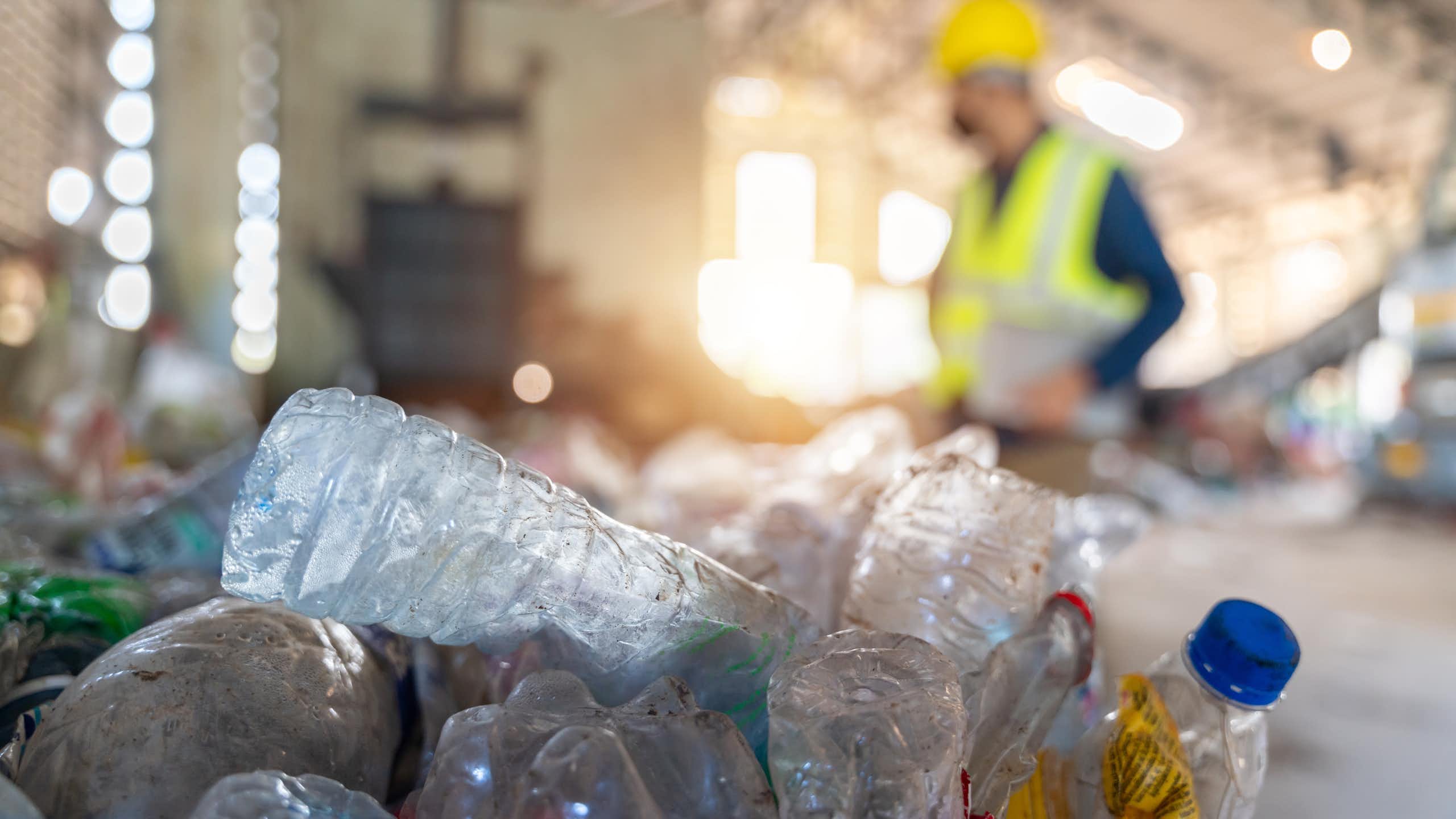 Bouteilles de plastique devant un ouvrier dans un chantier.