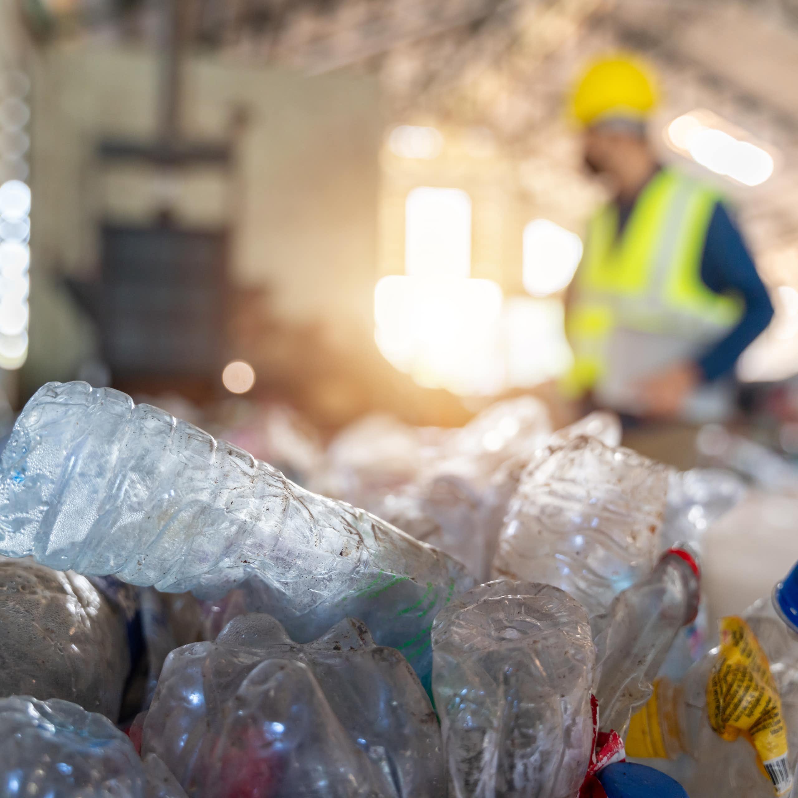 Bouteilles de plastique devant un ouvrier dans un chantier.
