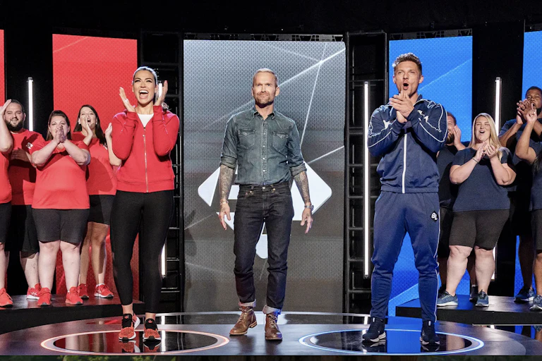 A group of people in team colours on a tv show.