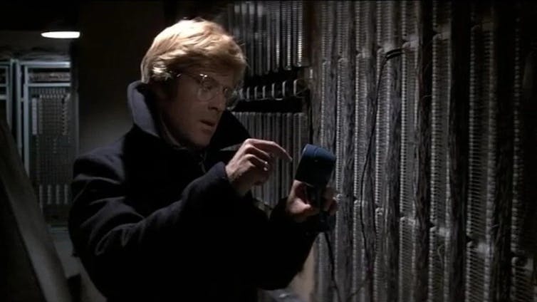 Un hombre revisa el teléfono en un edificio oscuro promedio.