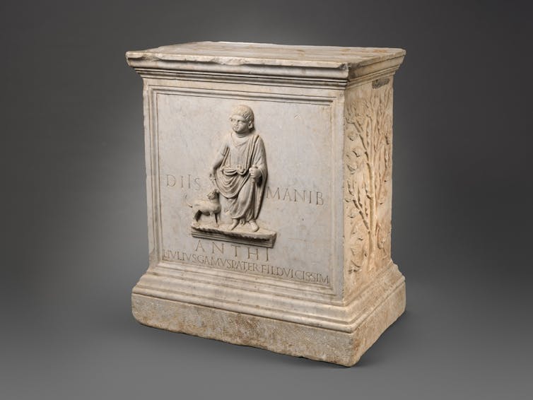 Altar funerario con un relieve de un niño y un perro.