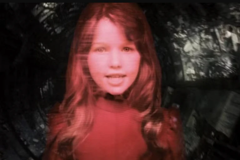Movie still of young girl colored with a red hue.