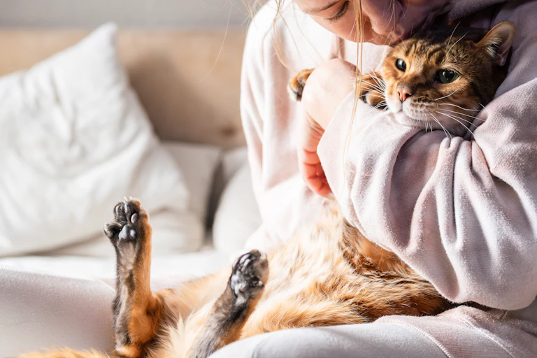 Mulher abraçando um gato