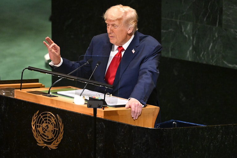 DOnald Trump stands at a podoim at the UN making a speech.