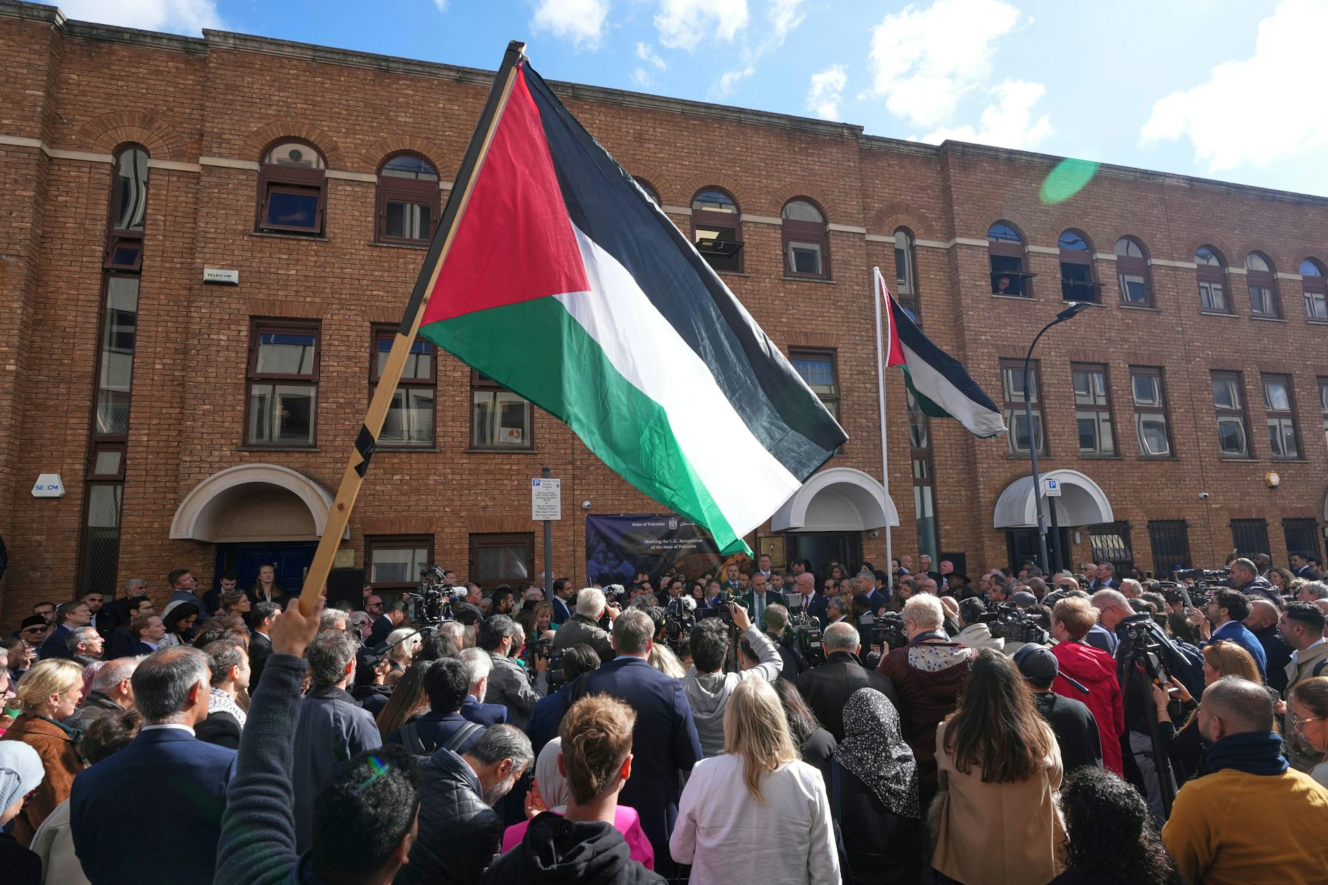 Une foule levant un drapeau palestinien