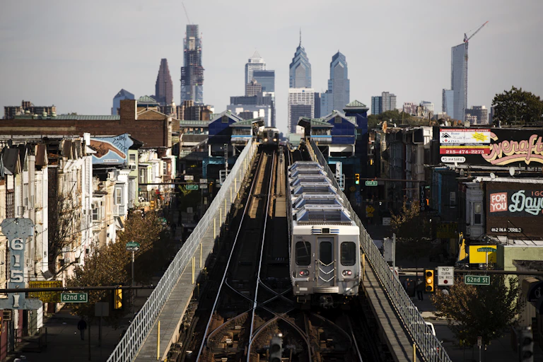 View of elevated train on tracks with Philadelphia skyline in background