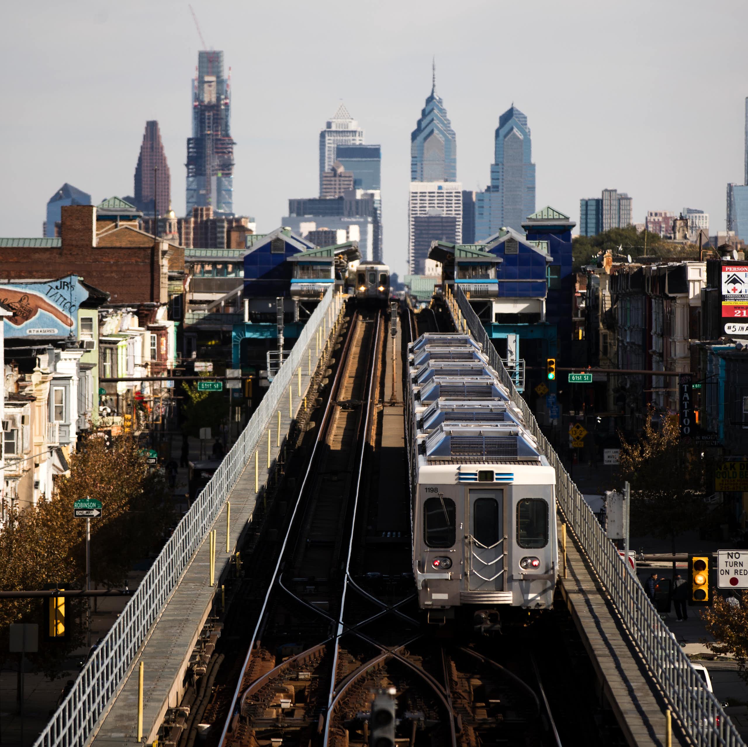 View of elevated train on tracks with Philadelphia skyline in background