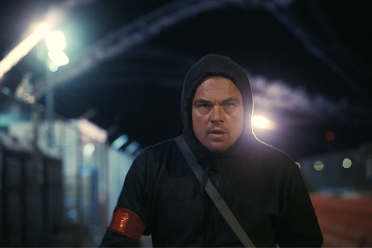 Leonardo DiCaprio as Bob Ferguson in a black hoodie at a detention complex.