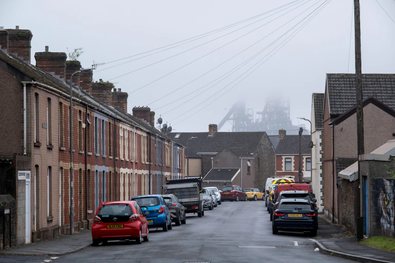 A row of terraced houses with the Port Talbot steelworks peeking over the top.