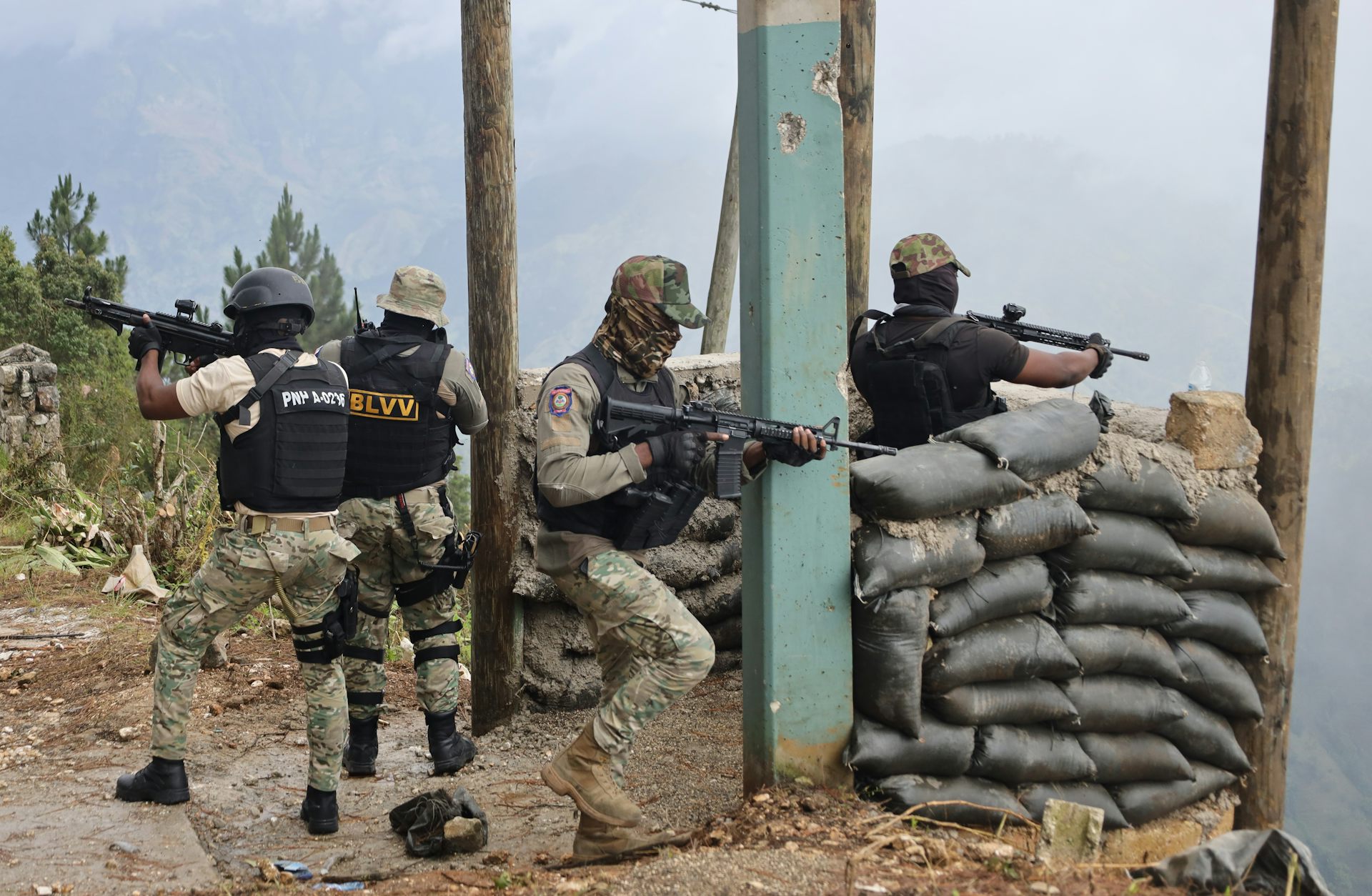 Haitian policemen fire their weapons after an attack by an armed gang.