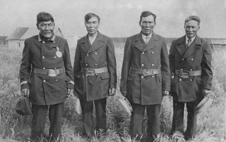 A row of men standing outdoors.
