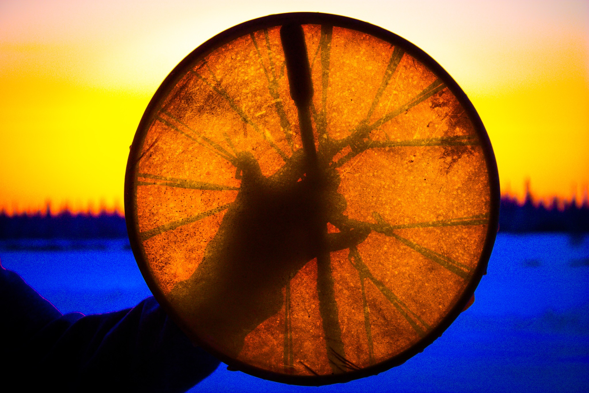 La mano que sostiene el tambor.