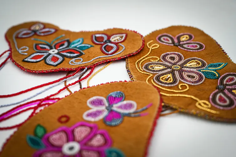 Colourful patterned beadwork on hide.