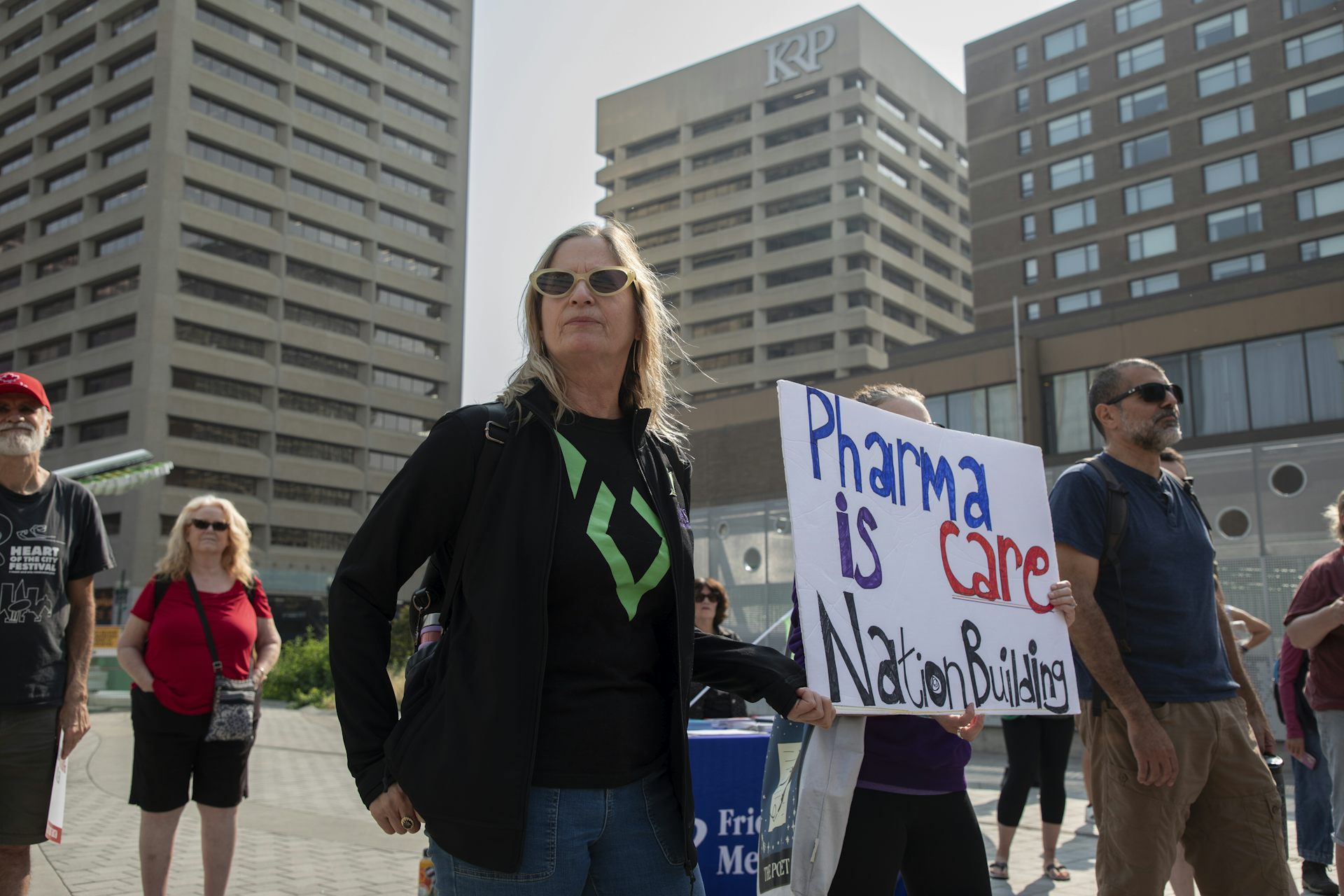 People at a demonstration holding a sign reading Pharmacare is nation building