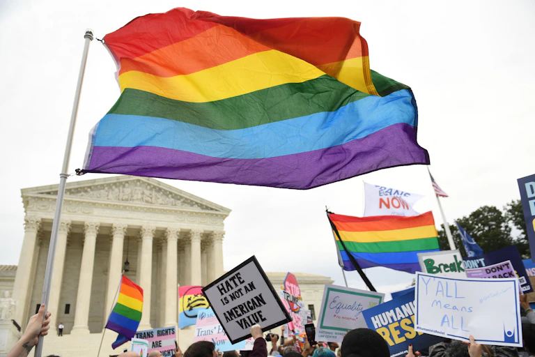 A rainbow flag flies in front of the U.S. Supreme Court building.