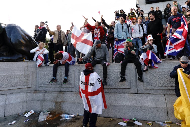 people climbing on a wall wearing flags.