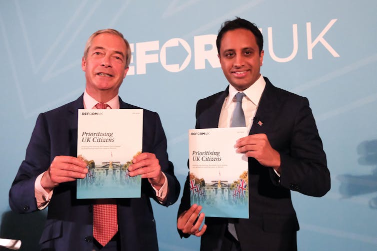 Nigel Farage and Zia Yusuf holding up booklets.