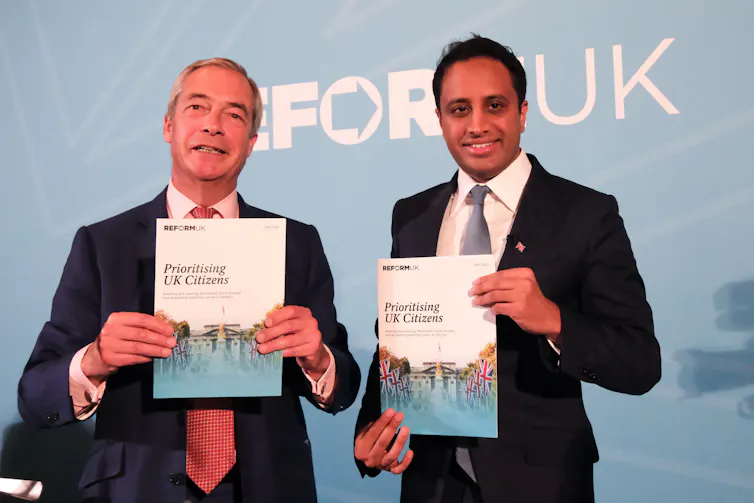 Nigel Farage and Zia Yusuf holding up booklets.