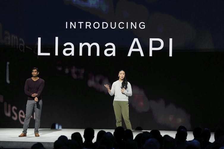 Two people stand on stage in front of a screen that says 'introducing Llama API'