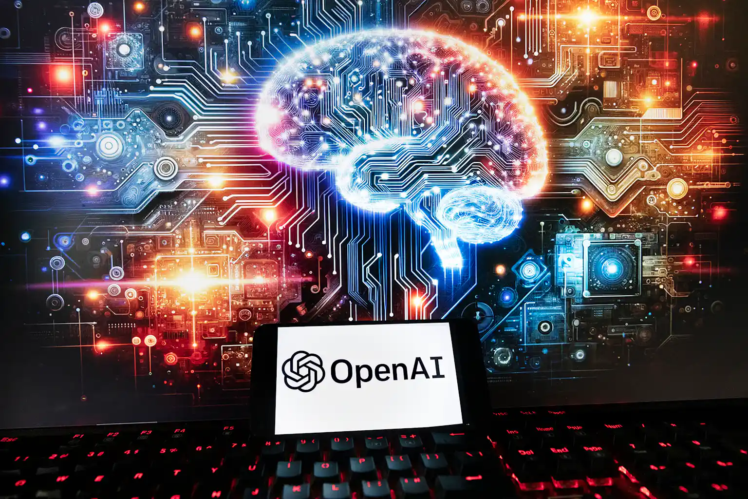 OpenAI logo on a phone and AI image on monitor