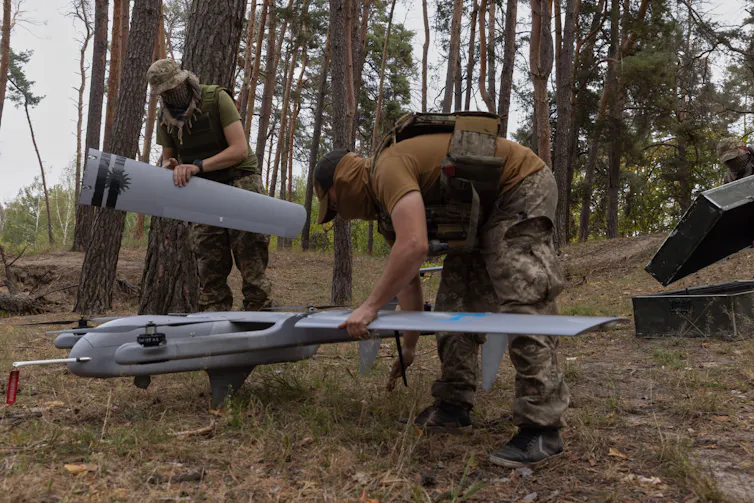 Ukrainian troops prepare to launch a drone.
