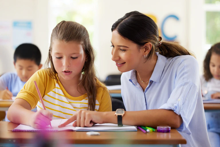 Adult helping child with reading in class
