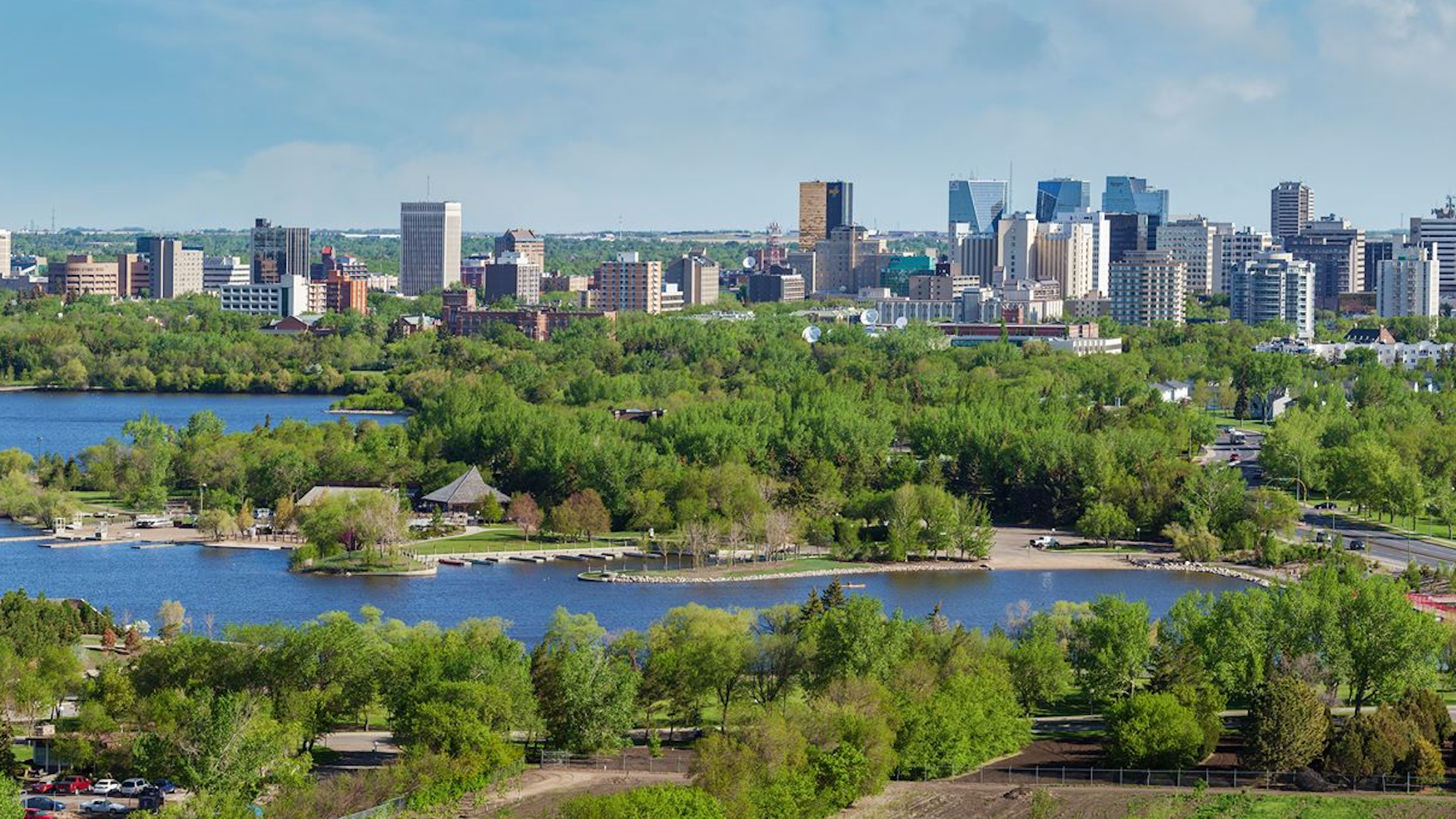 un lac au premier plan avec une ville en arrière-plan