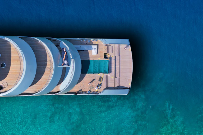 une photo aérienne d'un yacht dans une mer turquoise
