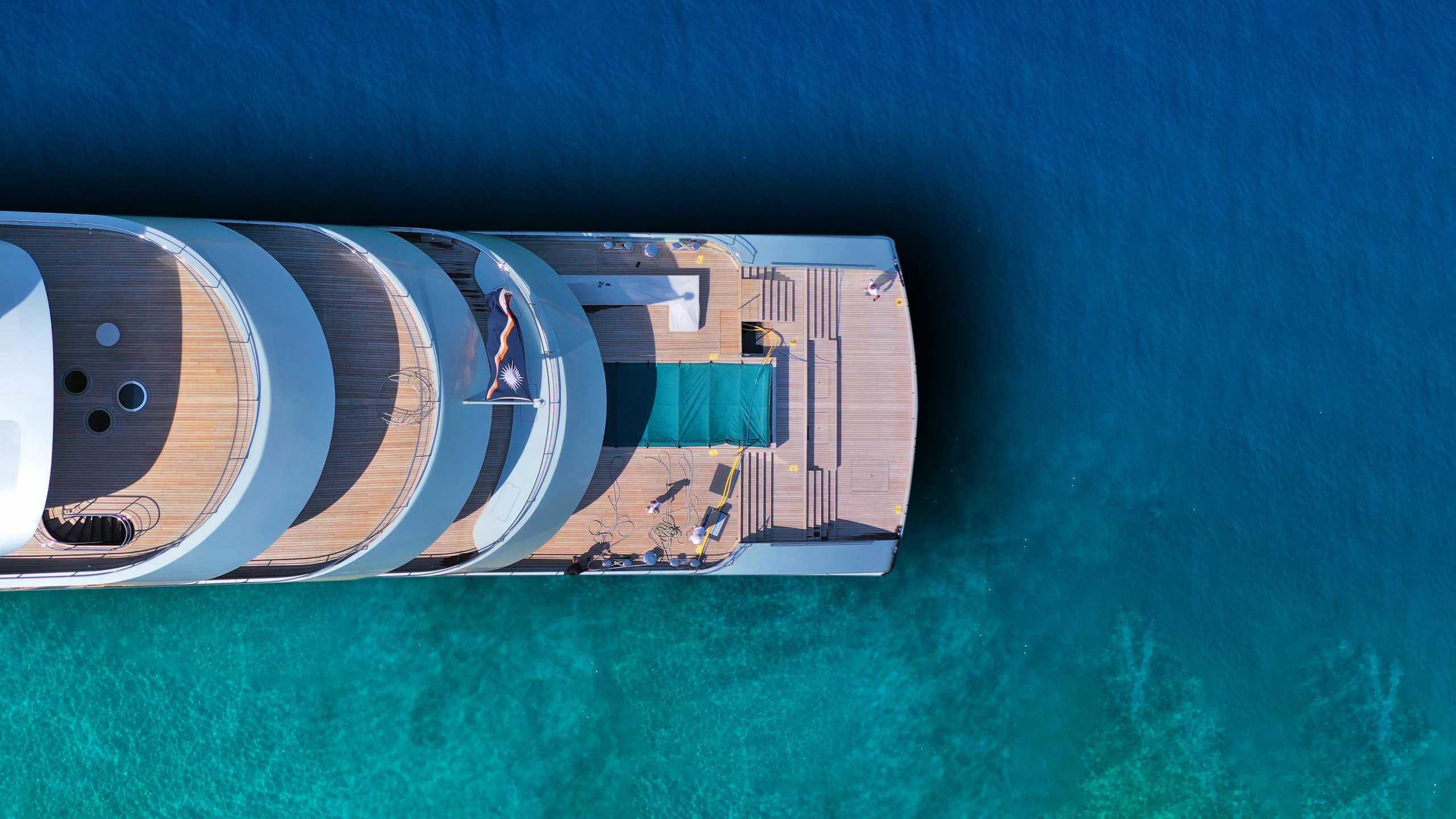 une photo aérienne d'un yacht dans une mer turquoise